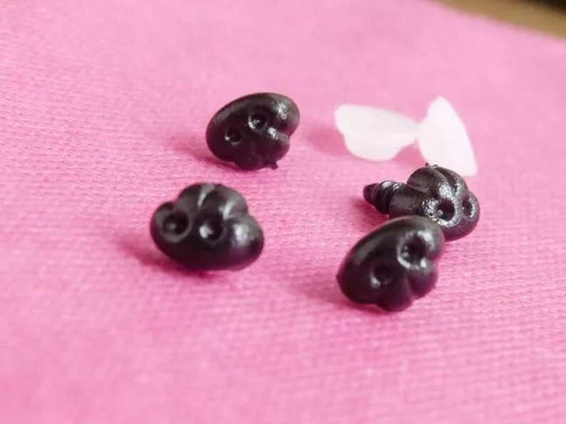 May include: Five black plastic safety eyes with a screw back. The eyes are heart-shaped and have a raised, textured surface.
