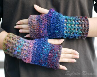 May include: A pair of colorful crocheted fingerless gloves with a lacy pattern. The gloves are made with a variety of shades of blue, purple, and brown yarn.