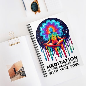 May include: A spiral notebook with a colorful illustration of a person meditating in a lotus position. The illustration is surrounded by a rainbow of colors and the text "Meditation is like hanging out with your soul".
