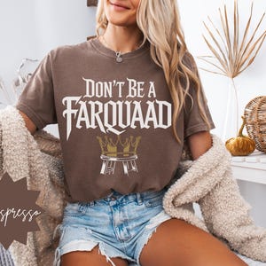 Close-up of a woman in casual loungewear wearing an espresso brown “Don’t Be a Farquaad” shirt with a humorous crown-on-stool design. Ideal for Shrek fans, pop culture enthusiasts, and casual outfits.