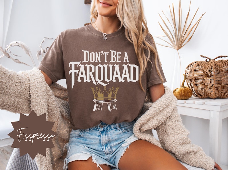 Close-up of a woman in casual loungewear wearing an espresso brown “Don’t Be a Farquaad” shirt with a humorous crown-on-stool design. Ideal for Shrek fans, pop culture enthusiasts, and casual outfits.