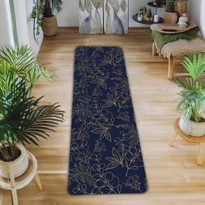 May include: A navy blue and gold floral patterned runner rug. The rug has a repeating pattern of stylized leaves and flowers.