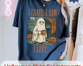 May include: Navy blue Halloween-themed t-shirt with the text "I CAME. I SAW. I LEFT." and a graphic of a sad ghost holding a mug. The design includes pumpkins and the words "Halloween Party." The shirt is for introverts.