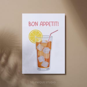 Puede incluir: Un estampado que presenta un refrescante t&eacute; helado con cubitos de hielo, una rodaja de lim&oacute;n y una pajita roja. Las palabras "BON APPETIT!" est&aacute;n escritas en rosa encima de la bebida. El estampado est&aacute; sobre un fondo blanco con el texto "SELENIQUE STUDIO" en la parte inferior.