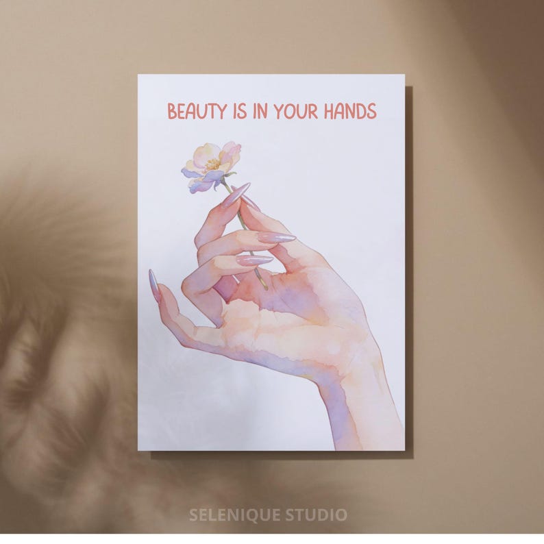 May include: A watercolor print featuring a hand holding a delicate flower. The text "BEAUTY IS IN YOUR HANDS" is displayed in red. The print has a soft, pastel color palette and is signed "SELENIQUE STUDIO".