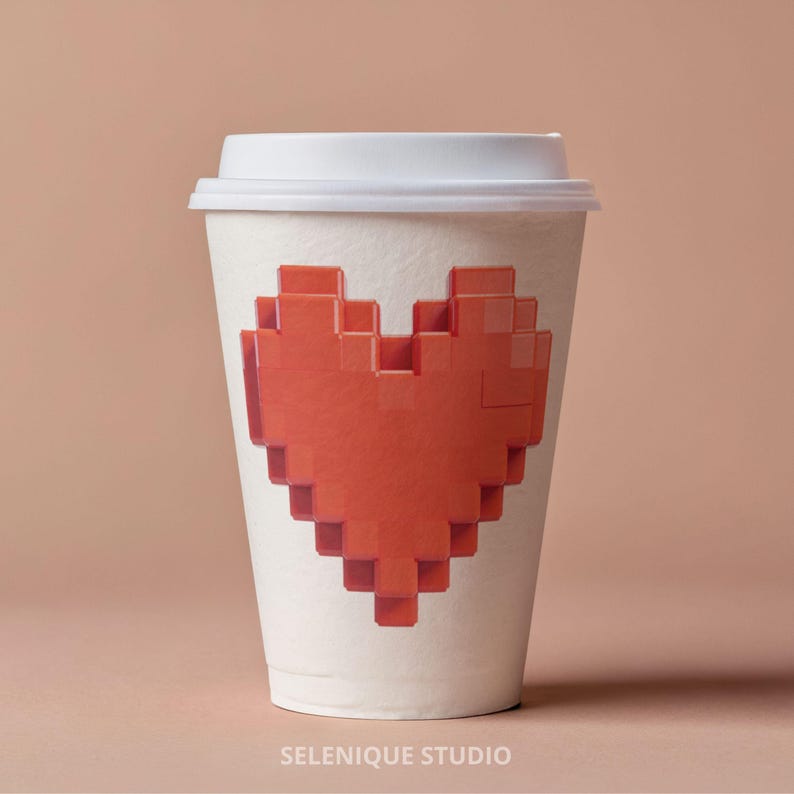 May include: A white paper coffee cup with a white lid. The cup features a large, pixelated red heart design. The words "SELENIQUE STUDIO" are printed at the bottom of the cup. The background is a solid, light brown color.
