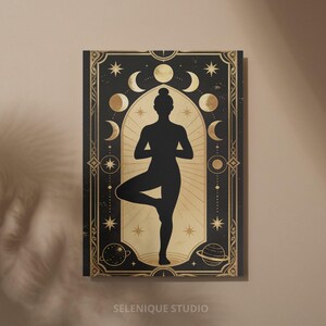 Pu&ograve; includere: Opera d'arte da parete nera e oro raffigurante la silhouette di una persona in posa yoga. L'opera ha un tema celeste con lune, stelle e pianeti. Il testo "SELENIQUE STUDIO" &egrave; in basso.
