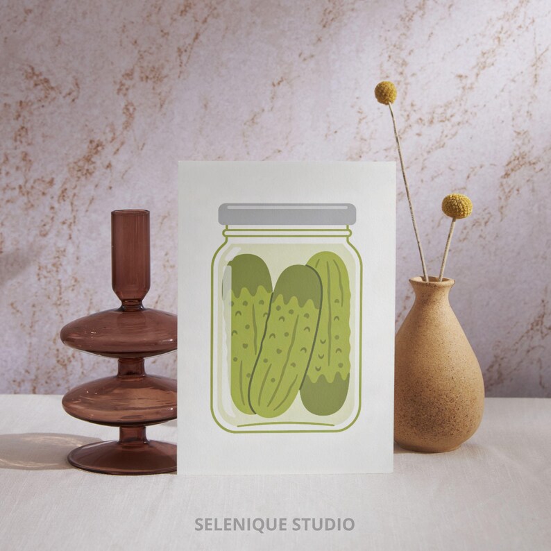 Puede incluir: Ilustraci&oacute;n de un tarro de pepinillos verdes con tapa gris. La ilustraci&oacute;n est&aacute; sobre un fondo blanco, con el texto "SELENIQUE STUDIO" en la parte inferior. Dise&ntilde;o minimalista.