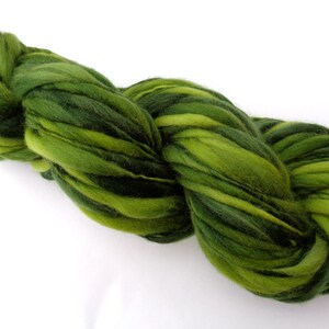May include: A skein of green and dark green hand-dyed wool yarn. The yarn is twisted and knotted, showing the different shades of green.