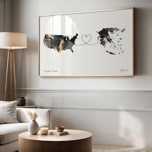 Living room featuring a framed USA and Greece map print hung above a white sofa and round wooden coffee table.