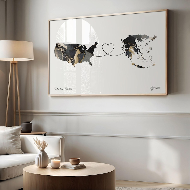 Living room featuring a framed USA and Greece map print hung above a white sofa and round wooden coffee table.