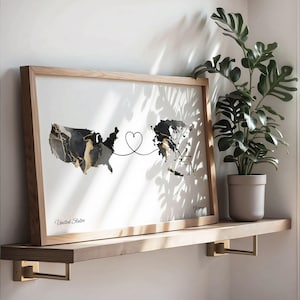 Wooden framed map print resting on a floating shelf next to a potted monstera plant, with natural shadow patterns cast across the wall.