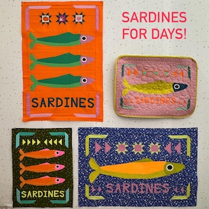 Puede incluir: Una colecci&oacute;n de coloridas obras de arte acolchadas con tem&aacute;tica de sardinas. Las piezas presentan dise&ntilde;os de peces en varios colores, incluyendo verde, naranja y amarillo, con la palabra "Sardinas" prominentemente mostrada. El texto "Sardines for Days!" tambi&eacute;n es visible.