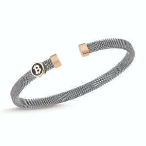 May include: A silver mesh bracelet with a gold-toned Bitcoin symbol charm.