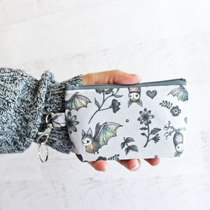 Estuche con cremallera y cierre de langosta para identificación, adorable y espeluznante, con diseño de murciélagos y flores: regalos por menos de 15 dólares