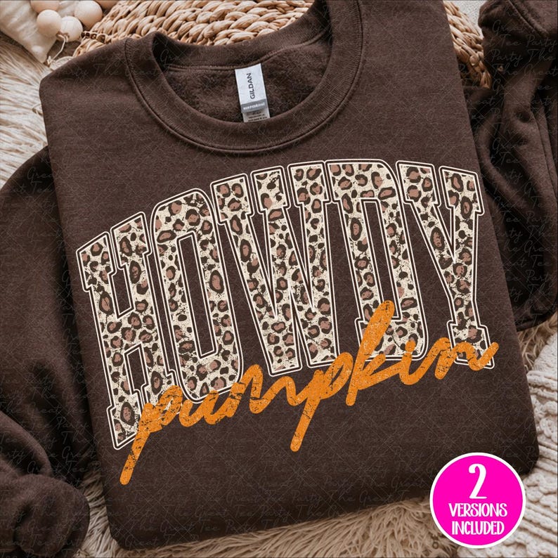 Puede incluir: Una sudadera de cuello redondo color marr&oacute;n oscuro con la palabra HOWDY en letras grandes de estilo bloque con un patr&oacute;n de leopardo beige y marr&oacute;n. Debajo de la palabra HOWDY, la palabra pumpkin est&aacute; escrita en cursiva naranja desgastada.