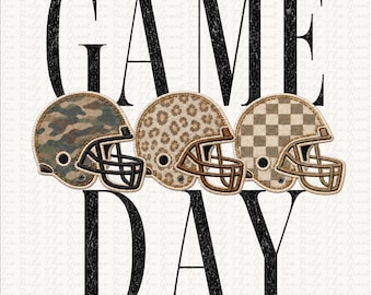 May include: A graphic design featuring the text GAME DAY in large black distressed letters. Between the words are three football helmets with different patterns: one with green camouflage, one with a brown leopard print, and one with a tan checkerboard.