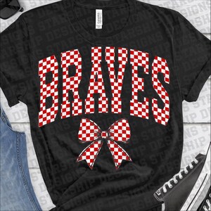 Puede incluir: Camiseta negra con la palabra "BRAVES" en un patr&oacute;n de cuadros rojos y blancos. Un gr&aacute;fico de lazo a juego est&aacute; debajo del texto. La camiseta es de cuello redondo.