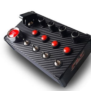Op de afbeelding: Een zwart carbonfiber paneel met meerdere rode drukknoppen en zwarte draaiknoppen. Het paneel heeft een zilveren schakelaar en een grote rode drukknop met het woord "Engine" erop. Het paneel is gelabeld "FLY Sim Controls".