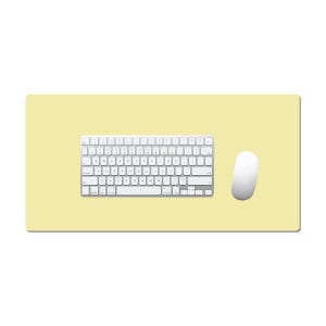Può includere: Un tappetino da scrivania rettangolare giallo chiaro con una tastiera wireless bianca con layout QWERTY standard e un mouse per computer wireless bianco posizionato a destra della tastiera sulla superficie liscia e a tinta unita.