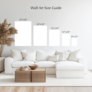 a living room with a white sofa and a coffee table. Above the sofa, there are five framed artworks of different sizes, ranging from 24"x36" to 20"x30" and 8"x12". The wall art guide provides the corresponding dimensions for each artwork.