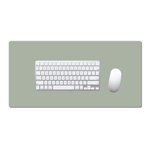 Puede incluir: Un conjunto de teclado y ratón inalámbricos blancos sobre una alfombrilla rectangular verde salvia. El teclado tiene una distribución estándar con teclas blancas y letras negras. El ratón es de forma ovalada y también blanco.