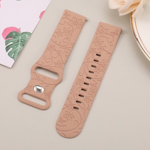 May include: Two light brown silicone watch bands with a floral pattern. The bands have a butterfly design and are made of soft, flexible silicone.