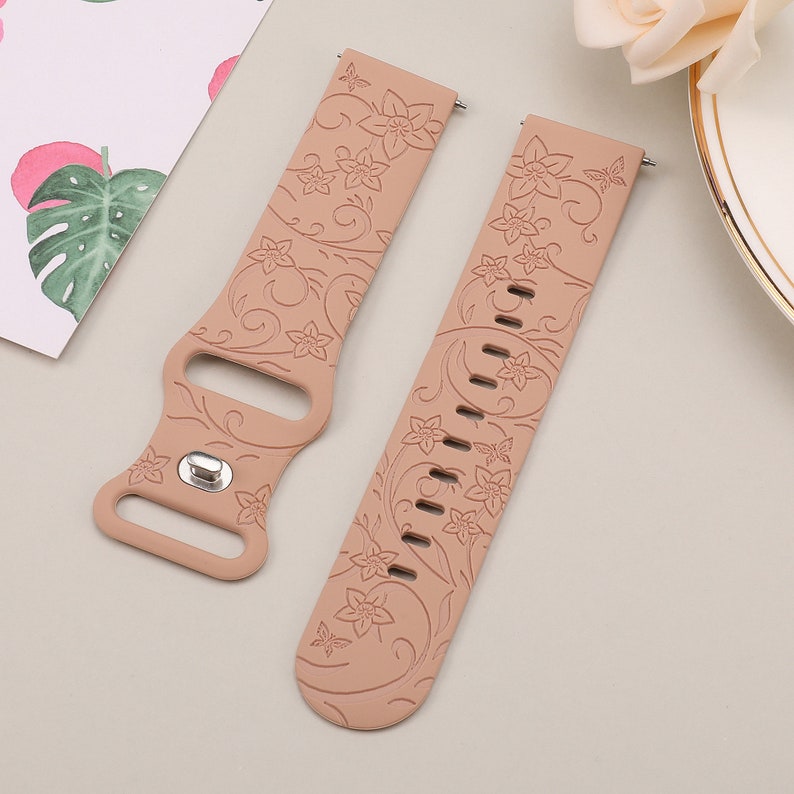 May include: Two light brown silicone watch bands with a floral pattern. The bands have a butterfly design and are made of soft, flexible silicone.