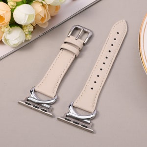 Puede incluir: Dos correas de reloj de cuero de color crema con cierres y conectores de metal plateado. Las correas tienen un dise&ntilde;o simple y elegante.