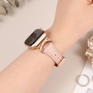 Puede incluir: Una correa de Apple Watch de oro rosa con un dise&ntilde;o de media luna. La correa est&aacute; hecha de cuero y tiene una hebilla de oro rosa.