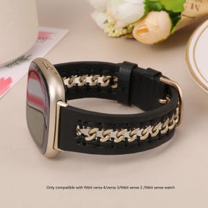 Könnte beinhalten: Schwarzes Leder-Uhrenarmband mit goldfarbenen Kettenakzenten. Das Armband ist für Fitbit Versa 4, Versa 3, Sense 2 und Sense Uhren konzipiert. Der Text "Only compatible with fitbit versa 4/versa 3/fitbit sense 2 /fitbit sense watch" ist sichtbar.