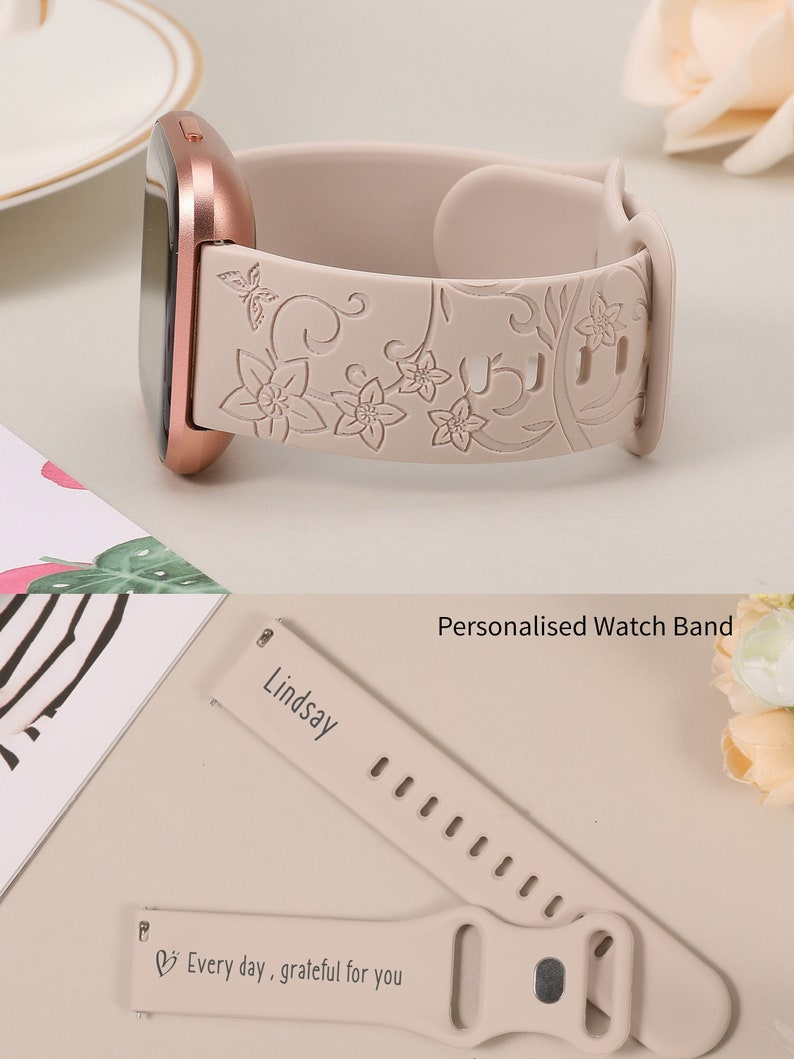 May include: A light pink silicone watch band with a floral design and a personalized inscription that reads "Lindsay" and "Every day, grateful for you".