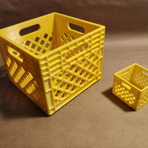 Puede incluir: Dos cajas de plástico amarillo estilo caja, una más grande que la otra. Ambas cajas tienen un patrón de cuadrícula y están hechas de un material ligero.