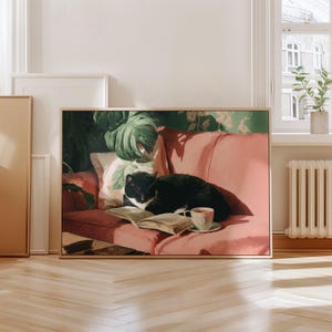 May include: A framed print depicts a black and white cat napping on a pink sofa. An open book and a cup of tea sit nearby. The background features a botanical print and a window with a view.