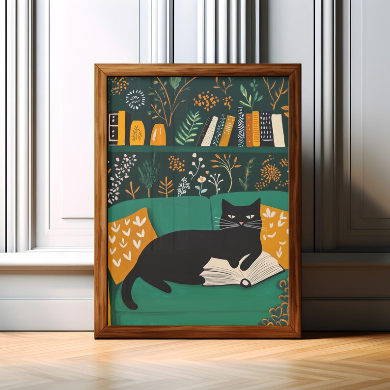 May include: A framed art print featuring a black cat lounging on a green sofa, reading a book. The background showcases a bookshelf with books and decorative elements. The print has a wooden frame and is set against a white wall.