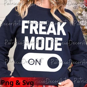 May include: Navy blue sweatshirt with the words "FREAK MODE ON" in large white block letters. The design includes a white toggle switch graphic. The sweatshirt is a casual, comfortable style.