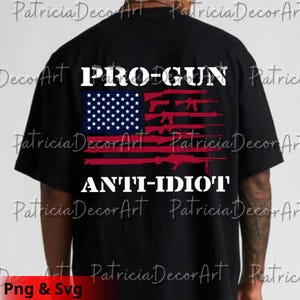 Peut inclure: T-shirt noir avec un motif graphique du drapeau américain, avec des fusils remplaçant les rayures. Les mots "PRO-GUN" et "ANTI-IDIOT" sont imprimés en blanc. Un vêtement décontracté.