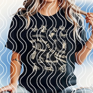 May include: Black t-shirt with a beige insect illustration design. The text "be kind to all kinds" is displayed in a circular arrangement. The design includes various insects such as butterflies, beetles, and bees.
