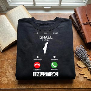 Può includere: Una tazza di ceramica bianca con manico nero e la scritta "But First, Coffee" in grassetto nero. La tazza è piena di un liquido scuro, probabilmente caffè, e poggia su una superficie chiara.