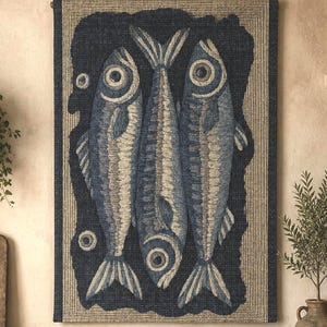 May include: A rectangular wall hanging featuring a textured, woven design of three fish in shades of navy blue, slate, and cream. The fish are arranged vertically against a dark navy background, framed by a light beige border with a visible woven pattern.