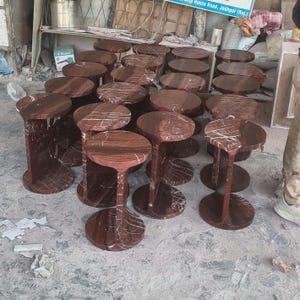 May include: A collection of multiple round side tables crafted from deep red marble with prominent white veining. Each table features a circular top supported by a vertical central pillar and a matching circular base, creating a uniform design.
