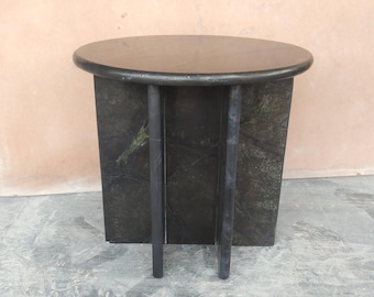 May include: A dark green marble side table with a round top and a rectangular base. The table has two black support legs. The table is approximately 20 inches tall and 18 inches wide.