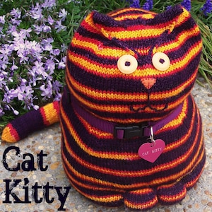 May include: A striped knitted cat toy with a purple, orange, and yellow color scheme. The cat has a black nose and large, round eyes. The toy is wearing a purple collar with a heart-shaped tag that says "Cat Kitty".