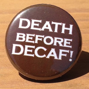 May include: A brown button with white text that reads "DEATH BEFORE DECAF!"