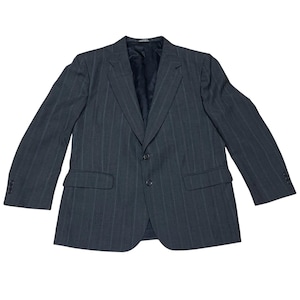 May include: A charcoal gray blazer with subtle pinstripes. The jacket features a two-button closure, notched lapels, and two front pockets. The sleeves have three buttons at the cuffs. The blazer is a classic style, suitable for formal or business attire.