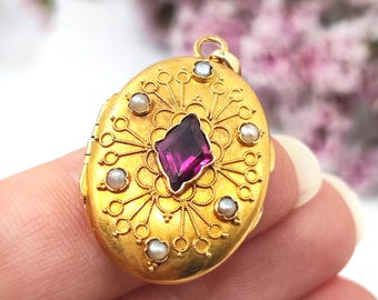Peut inclure: Médaillon ovale en or avec une pierre précieuse violette centrale et de petites perles. Le médaillon présente des détails de filigrane complexes et une conception à charnière. Un bijou délicat.