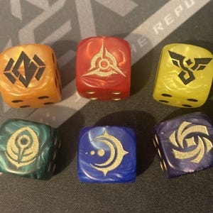 Può includere: Sei dadi colorati e marmorizzati con simboli dorati. I dadi sono arancioni, rossi, gialli, verdi, blu e viola. Ogni dado ha un simbolo diverso e un numero di punti. Adatti per giochi da tavolo.