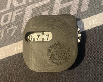 May include: A black plastic dice rolling box with a white d20 symbol and a window displaying the numbers 0, 7, 3, and 1.