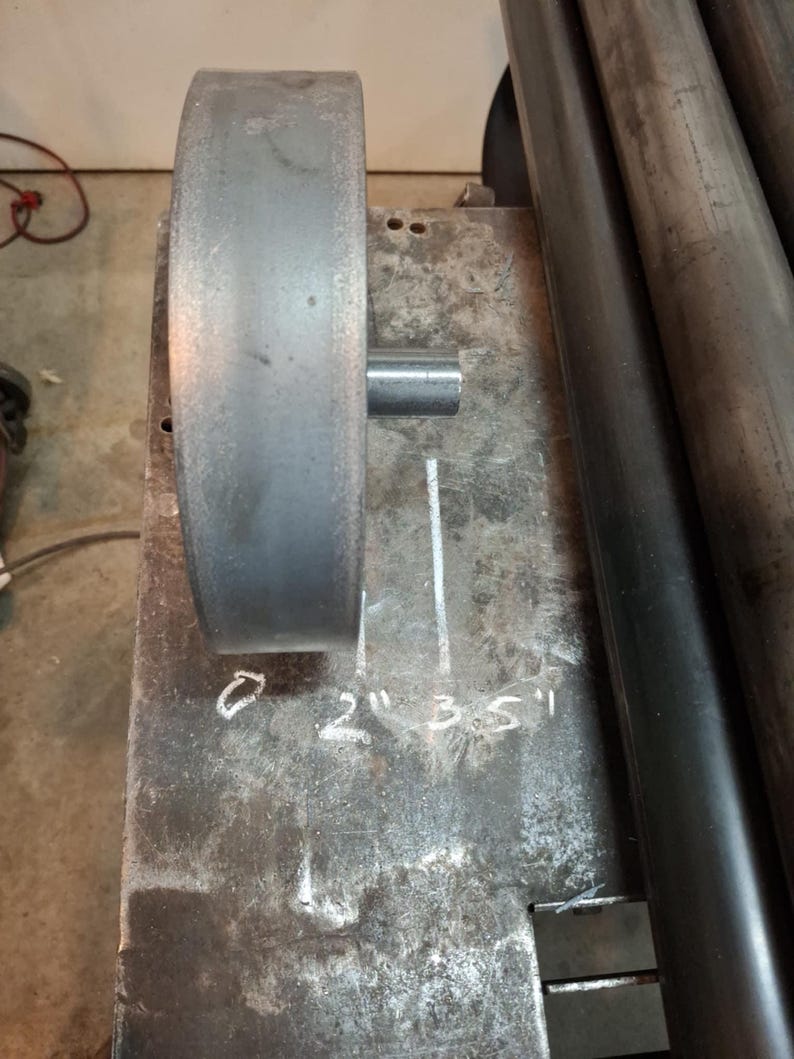 May include: A metal roller with a diameter of 2 inches, 3.5 inches, and 5 inches. The roller is marked with the measurements in inches.