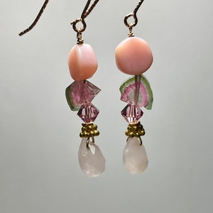 May include: Pink and green gemstone earrings with gold hooks. The earrings feature pink and green tourmaline, pink quartz, and gold beads.
